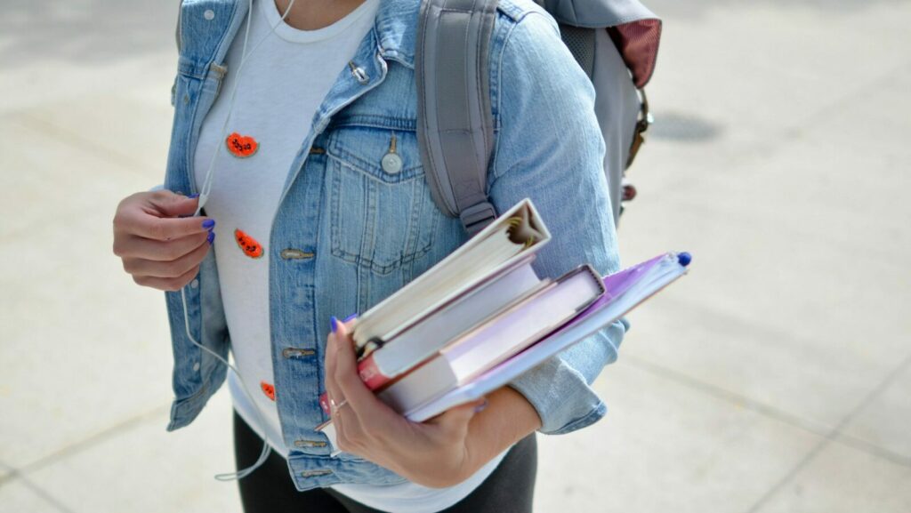 Photo by Element5 Digital woman wearing blue denim jacket holding book